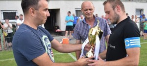 Dominik Heller, kapitán Olešníka, dostává od šéfa jihočeského fotbalu Jana Jílka pohár za vítězství v krajském přeboru.